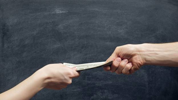 Man handing over dollar bills